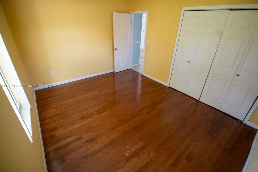 9041 Southwest 88th Street, Unit 9041 Miami, FL 33173 - Photo 23 of 34 an empty room with wooden floor