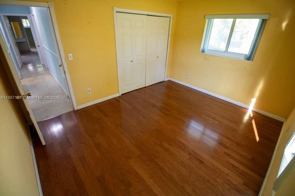9041 Southwest 88th Street, Unit 9041 Miami, FL 33173 - Photo 24 of 34 a view of an empty room with wooden floor and a window