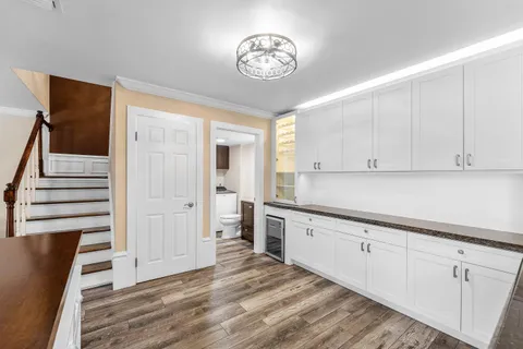 a view of a kitchen with wooden floor and cabinets