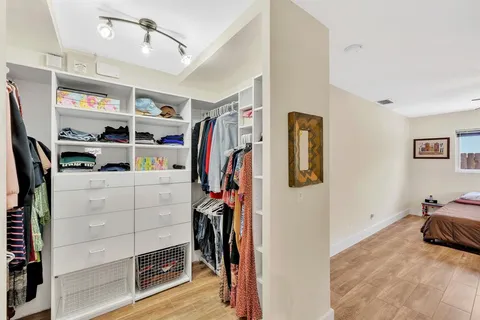 a view of a hallway with wooden floor and closet area