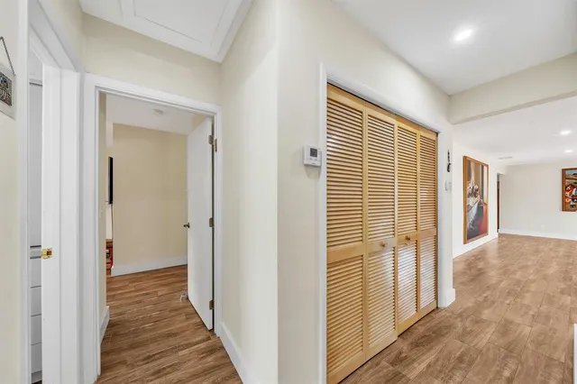 a view of a hallway with wooden floor and windows