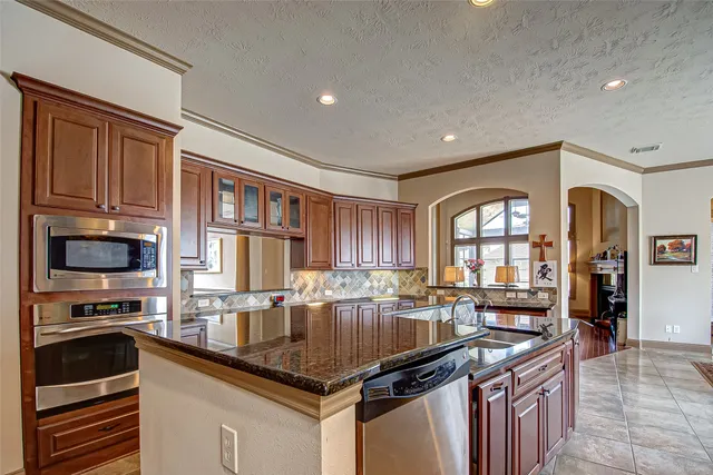 a kitchen with granite countertop a stove sink and cabinets
