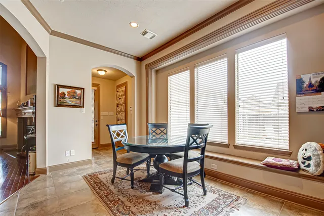 a dining room with furniture and a floor to ceiling window