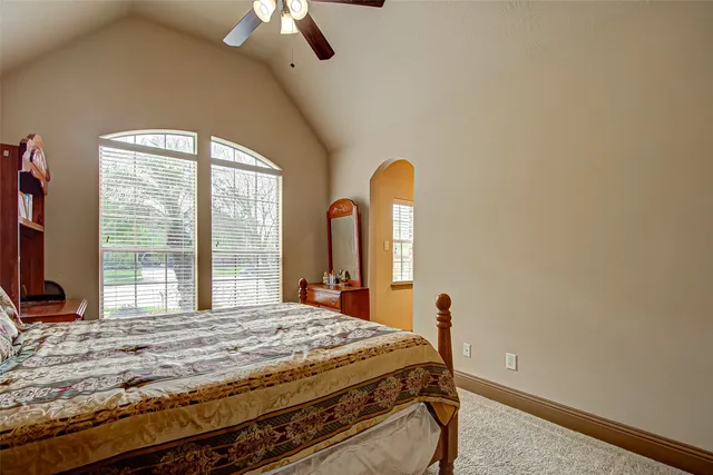 a bedroom with a bed and a flat tv screen on dresser