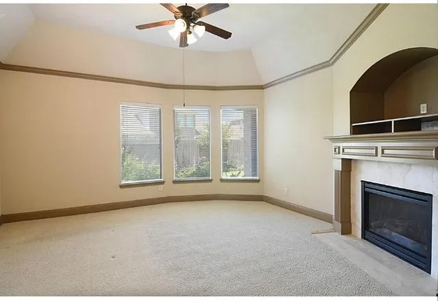 a view of an empty room with a fireplace and a window