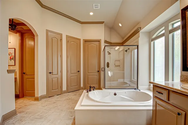 a bathroom with a tub a sink and a large mirror