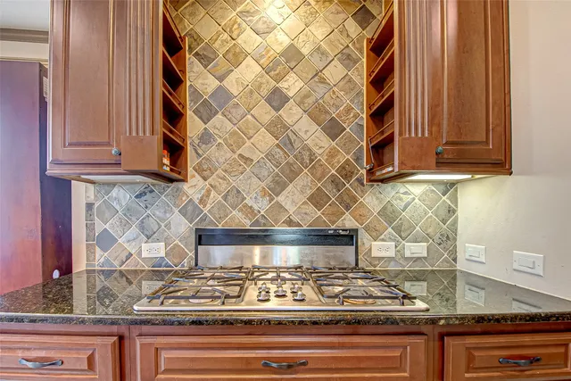 a kitchen with granite countertop white cabinets and a wooden floor