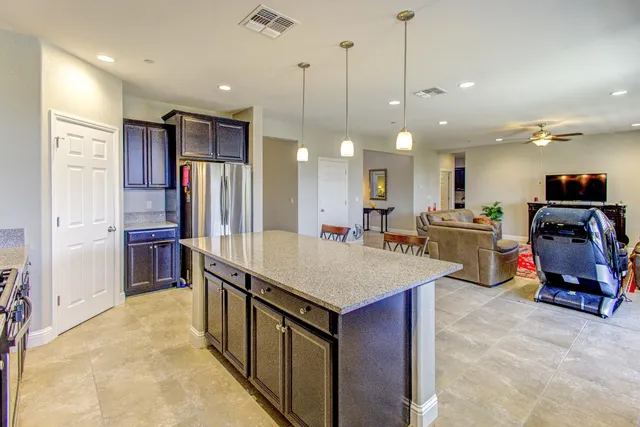 a living room with furniture kitchen view and a large window