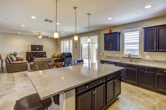 a living room with furniture kitchen view and a flat screen tv