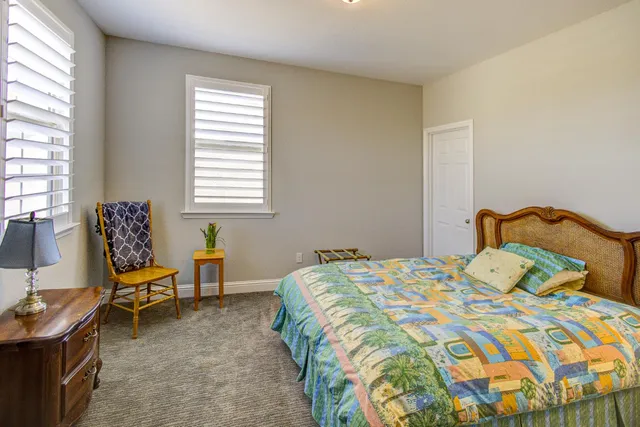 a bedroom with a bed and a flat tv screen on wall