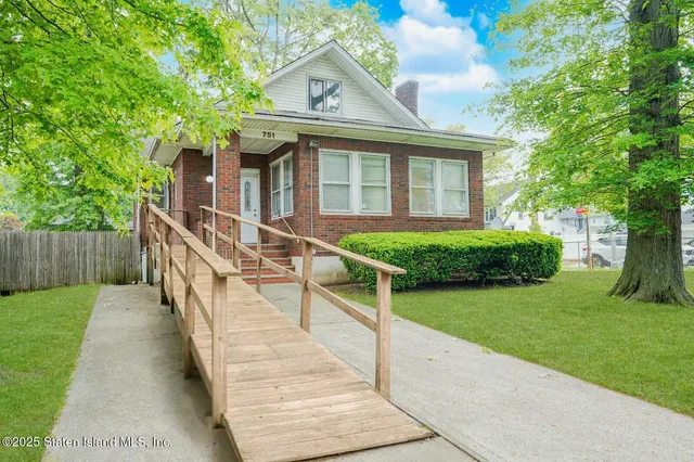 a front view of a house with yard and green space