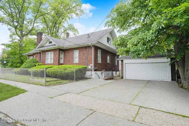 a white house that has a tree in front of it