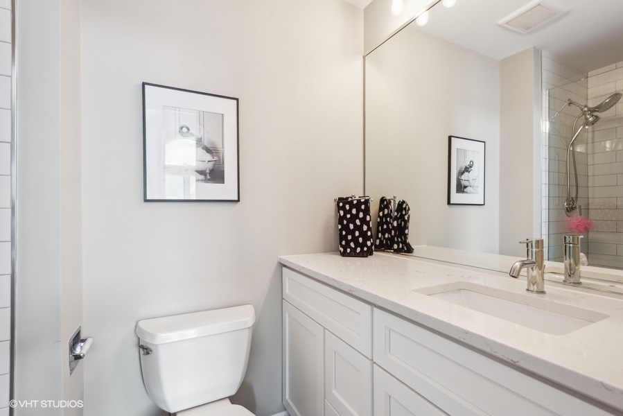 1231 West Fletcher Street, Unit A Chicago, IL 60657 - Photo 11 of 20 a bathroom with a toilet sink and mirror