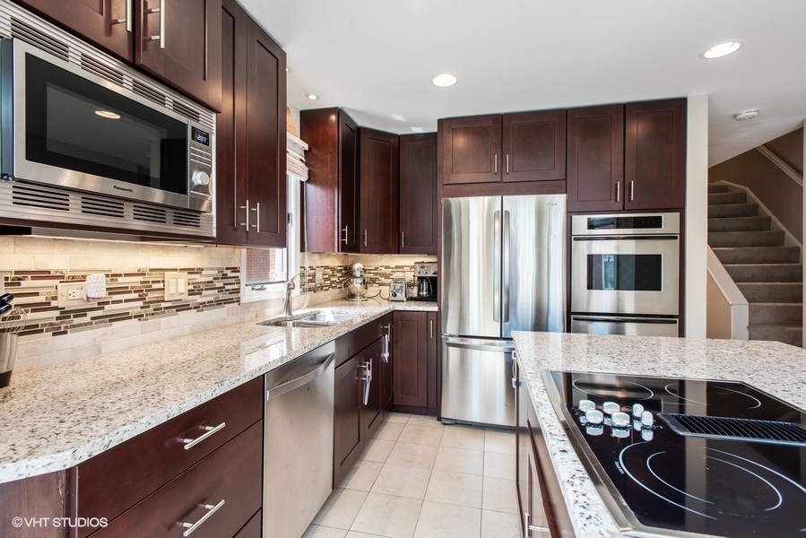 1231 West Fletcher Street, Unit A Chicago, IL 60657 - Photo 6 of 20 a kitchen with stainless steel appliances granite countertop a refrigerator and a stove top oven