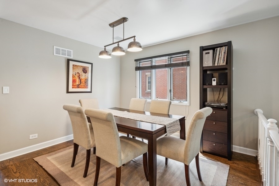 1231 West Fletcher Street, Unit A Chicago, IL 60657 - Photo 7 of 20 a view of a dining room with furniture wooden floor and chandelier