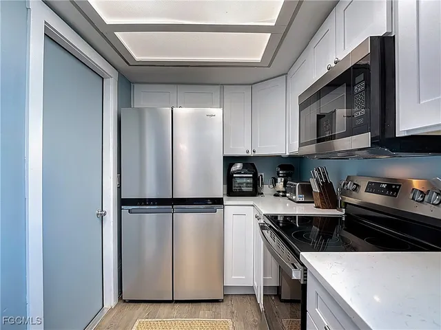 a kitchen with a refrigerator and a stove top oven