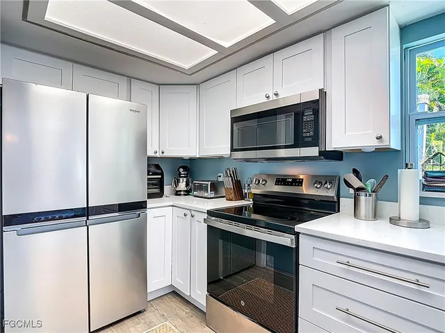 a kitchen with stainless steel appliances white cabinets and a refrigerator
