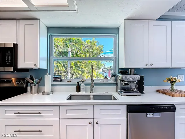 a kitchen with appliances a sink and cabinets