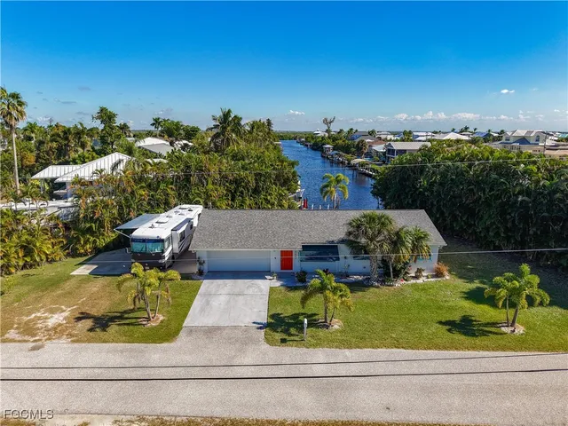 an aerial view of a house with a yard and lake view
