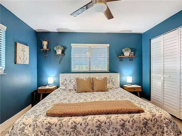 a bedroom with a bed and painting on the wall