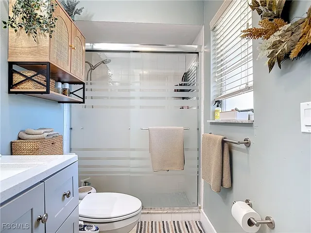 a bathroom with a granite countertop toilet sink and shower