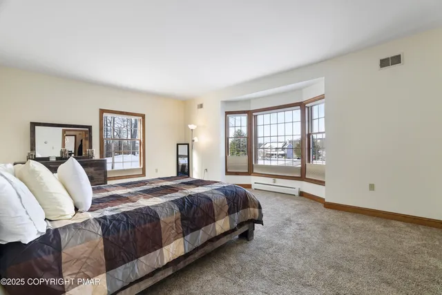 a large bed sitting in a bedroom next to a window