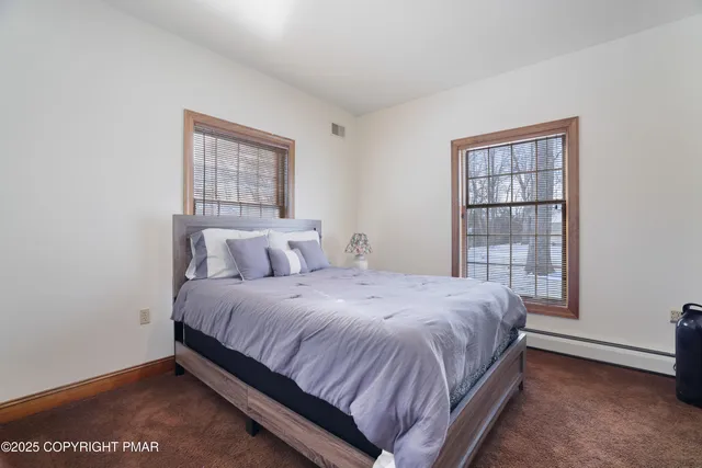 a bedroom with a bed and large windows