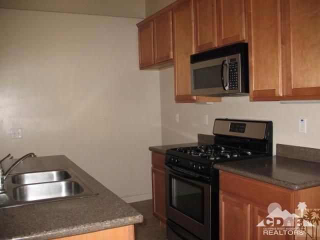 10762 San Pablo Road Desert Hot Springs, CA 92240 - Photo 3 of 9 a kitchen with stainless steel appliances granite countertop a stove a microwave and sink