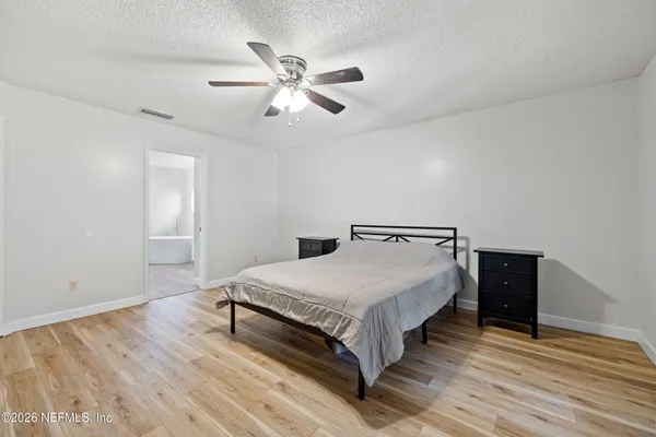 a bedroom with a bed and a bookshelf with wooden floor