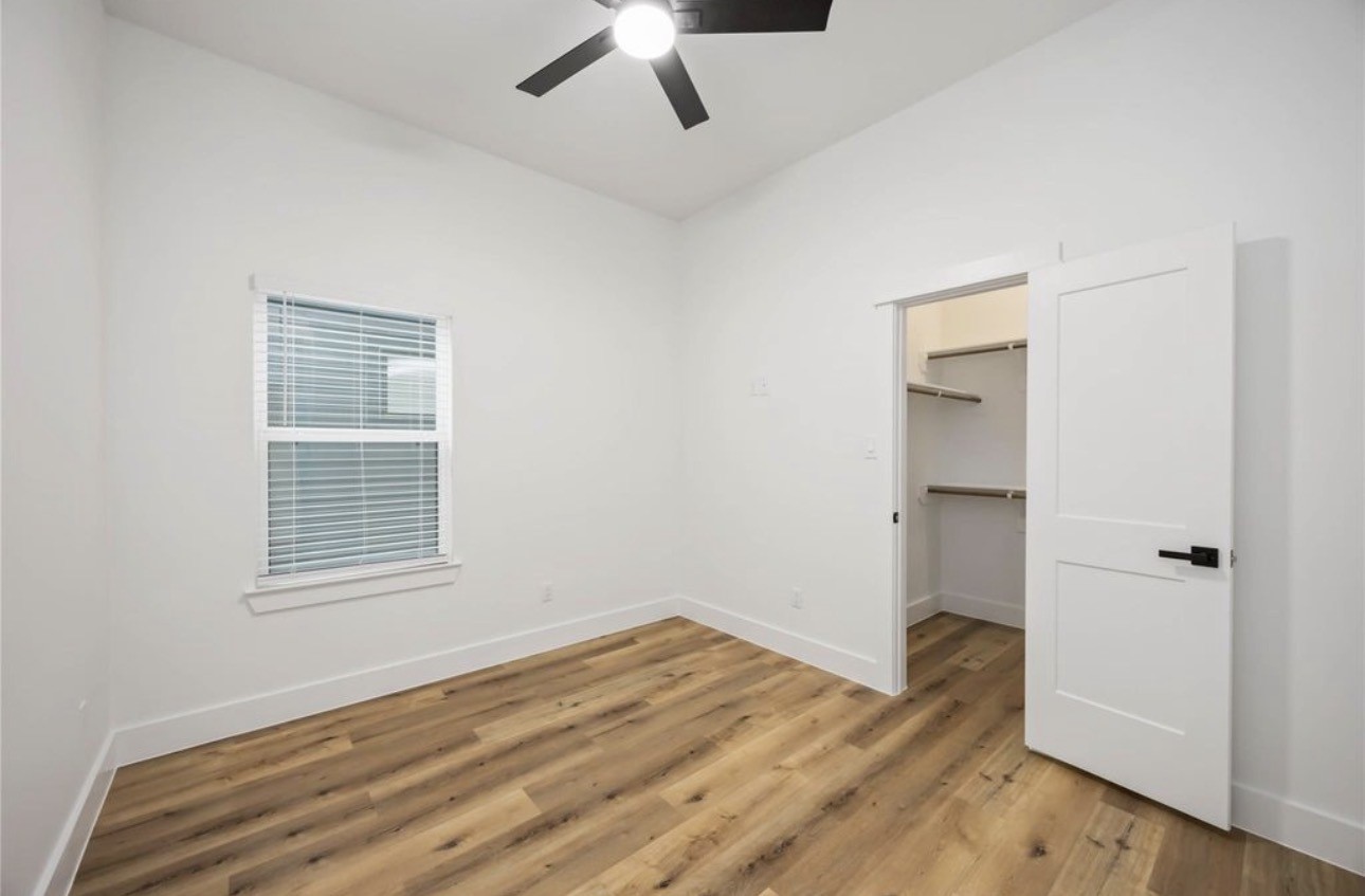 8011 Cora Street, Unit A Houston, TX 77088 - Photo 8 of 14 an empty room with wooden floor cabinet and windows