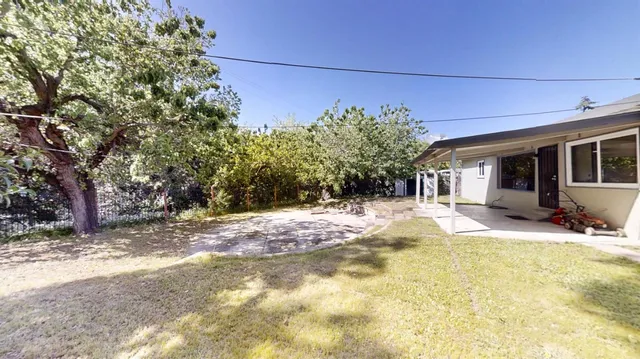 a view of a house with backyard and sitting area