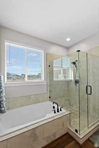 3678 Spiral Springs Road, Unit 204 Tooele, UT 84074 - Photo 33 of 59 Built-in soaking tub with matte black fixtures, glass-enclosed shower with a pebble floor, and large format tile surrounds