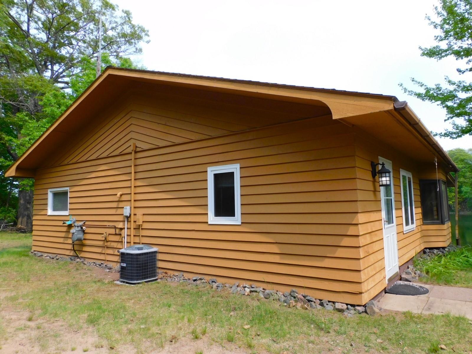 67820 Hanes Road Iron River, WI 54847 - Photo 46 of 50 View of home's exterior cedar siding & featuring cooling unit