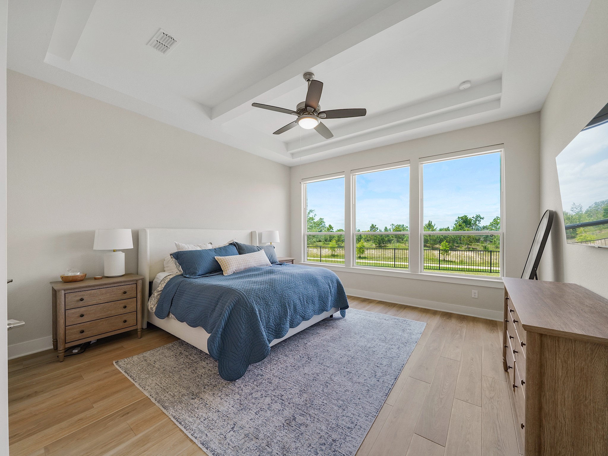 5802 Emerald Ranch Lane Fulshear, TX 77441 - Photo 21 of 45 The spacious primary suite offers a peaceful retreat with oversized windows, tray ceilings, and plenty of room for a seating area while enjoying serene backyard views.