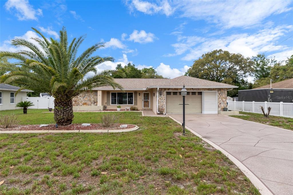 3217 Abeline Road Spring Hill, FL 34608 - Photo 1 of 48 a front view of a house with garden