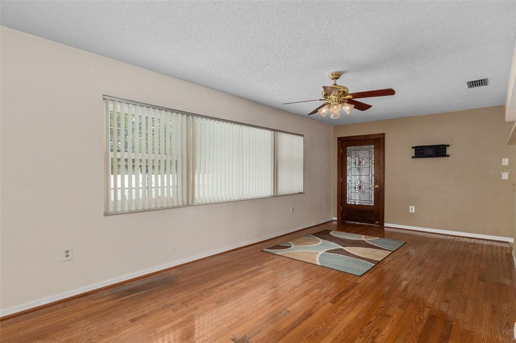 3217 Abeline Road Spring Hill, FL 34608 - Photo 14 of 48 a view of an empty room with window and wooden floor