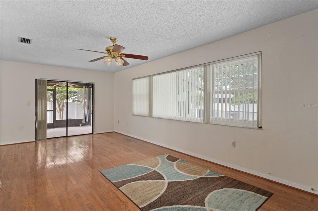 3217 Abeline Road Spring Hill, FL 34608 - Photo 17 of 48 a view of a livingroom with wooden floor and a ceiling fan