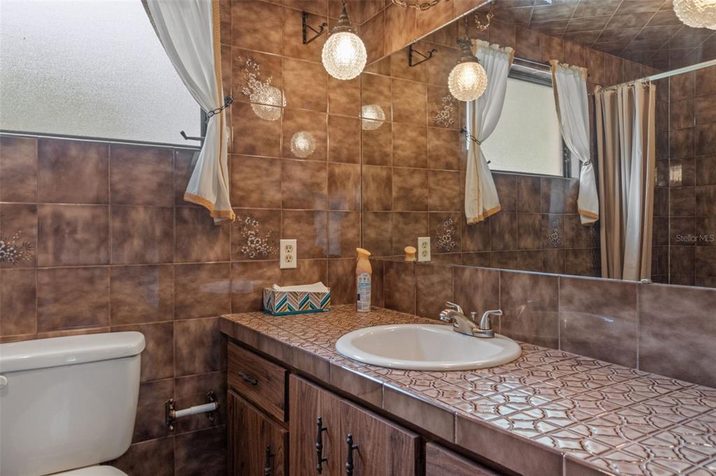 3217 Abeline Road Spring Hill, FL 34608 - Photo 40 of 48 a bathroom with a sink and mirror
