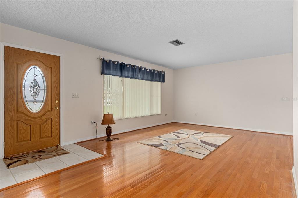 3217 Abeline Road Spring Hill, FL 34608 - Photo 10 of 48 a view of an empty room with window and wooden floor