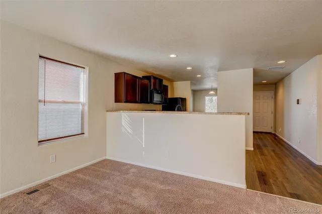 a view of a kitchen with furniture and wooden floor