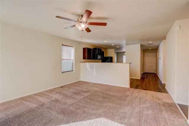 a view of empty room with wooden floor and window