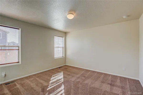 an empty room with windows and closet