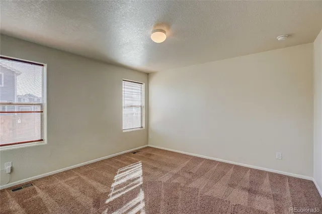 an empty room with windows and closet
