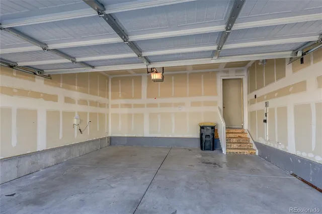 a tall buildings with trees and cars parked in front of it