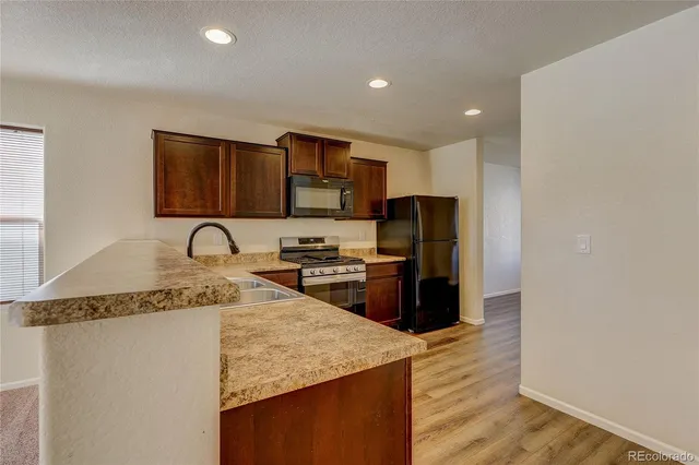 a kitchen with stainless steel appliances granite countertop a sink refrigerator and microwave