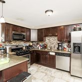 a kitchen with a refrigerator a microwave a sink and cabinets