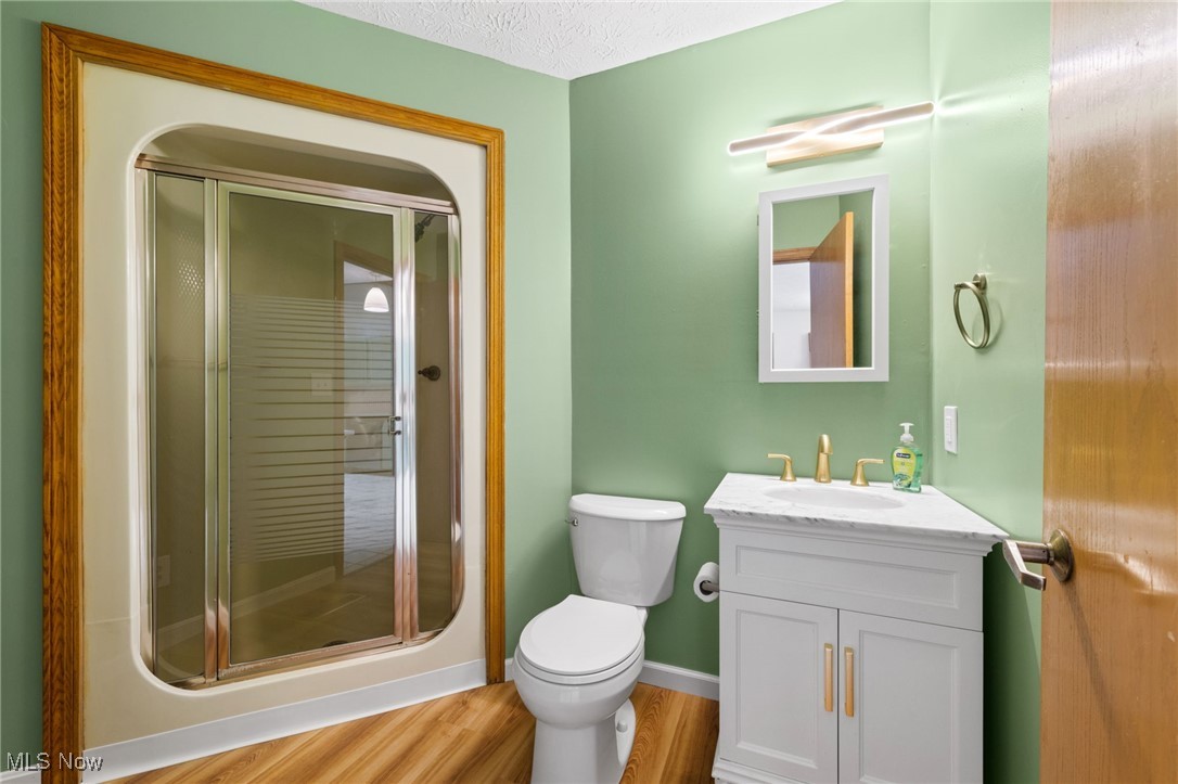 163 Burns Road Elyria, OH 44035 - Photo 8 of 37 Full bathroom with vanity, a shower stall, and wood style floors