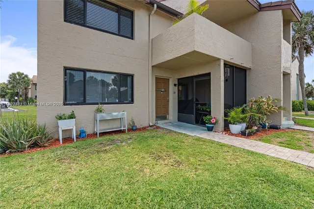 a view of a house with a small yard and plants