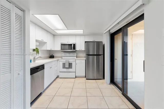 a kitchen with white cabinets and white appliances
