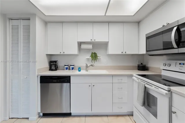 a kitchen with white cabinets stainless steel appliances and sink